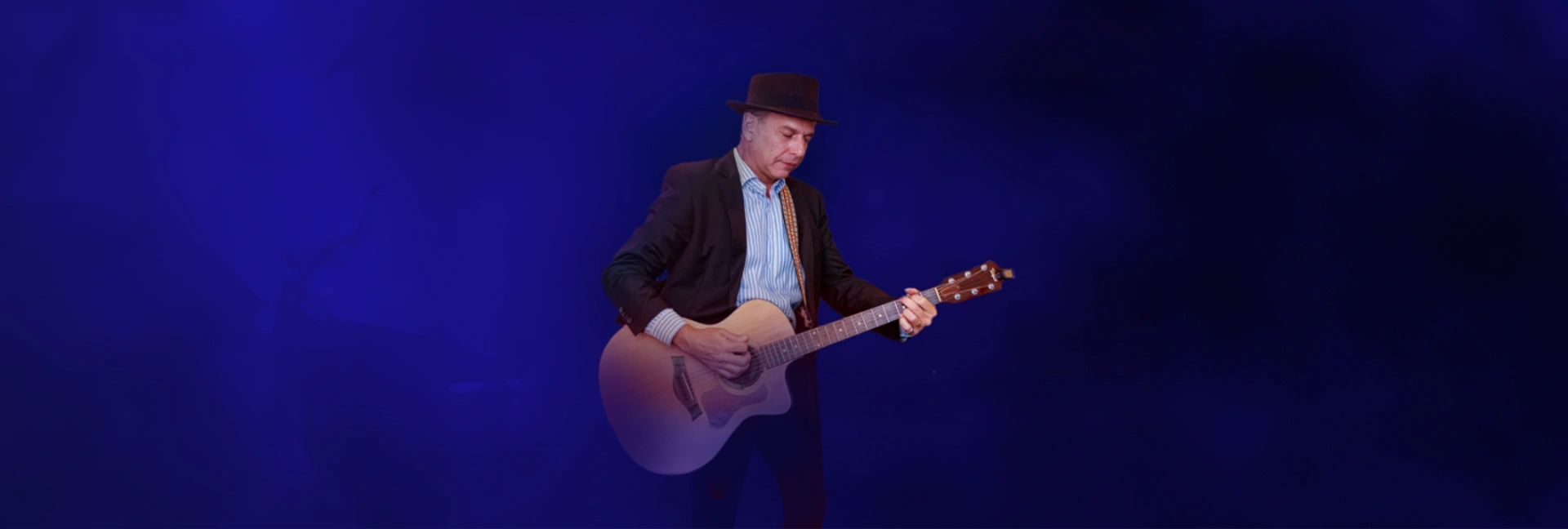 Prof. Alfredo Bravo tocando violão no palco