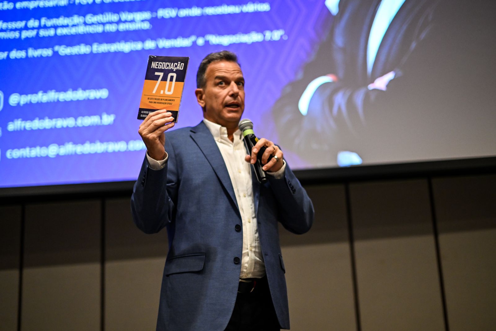 Prof. Alfredo Bravo apresentando o livro Negociação 7.0 durante palestra sobre comunicação